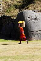 cusco, Perú, 2015 - hombre en tradicional disfraz que lleva cesta de amarillo pétalos foto