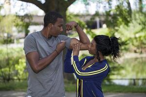 negro mujer y hombre inspeccionando su bíceps foto