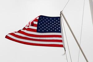 United States Flag Flying From Nautical Flag Pole Overcast Sky photo