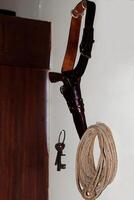 Columbia, CA, 2023 - Old Pistol And Holster Belt Rope And Key Wall Display photo