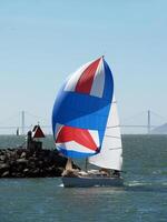 Berkeley, CA, 2007 - Sailboat rounding breakwater with spinnaker sail and main photo