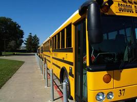 Carmichael, CA, 2006 - Yellow school bus parked along sidewalk curb photo