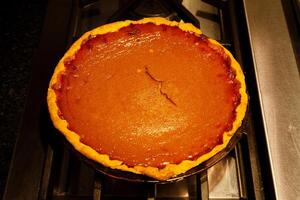 Fresh Homade Whole Pumpkin Pie Cooling On Stove Top photo