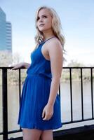 Blond Woman In Blue Dress Standing Outdoors photo