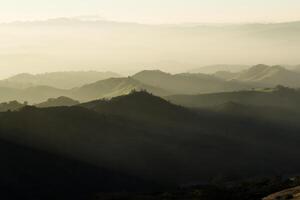 Late Afternoon Light Over Through Mist On Hills photo