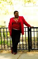 de edad mediana africano americano mujer en pie al aire libre rojo parte superior foto