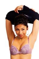 Attractive Young Woman Pulling Off Shirt With Purple Bra photo