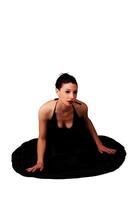 Slim Caucasian Woman Kneeling On White Background In Black Dress photo