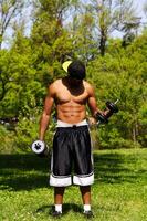 African American Man Lifting Weights Outdoors At Park photo