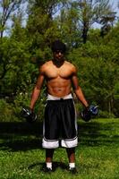 African American Man Holding Weights Outdoors In Park photo