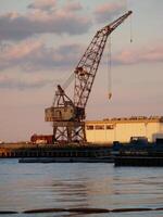 Boston, MA, 2008 - Rusted Grey Crane Harbor Against Cloudy Sky photo