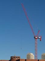 Boston, MA, 2008 - Red Construction Crane In Clear Blue Sky With Building Tops photo