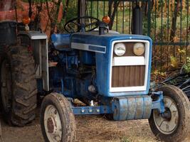 justa robles, California, 2006 - antiguo azul tractor en el cobertizo con barro foto