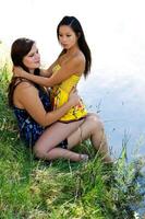 Asian American Woman Sitting On Caucasian Woman's Lap photo