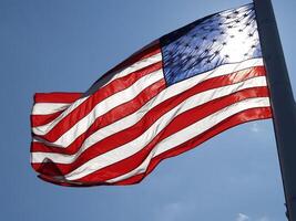 Unites States Flag Streaming With Sun Behind It photo