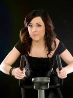 Young Asian American Woman on Exercise Bike photo