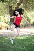 joven Hispano adolescente mujer saltando al aire libre foto