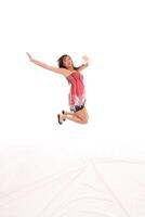 Young Asian American teen woman jumping red dress photo