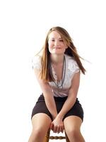 Young woman in black skirt sitting on stool photo