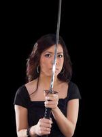 Young oriental woman with sword before face photo