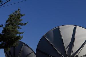 Back Side Of Communication Dishes Pointing Up At Blue Sky photo