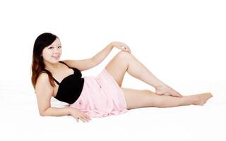 joven asiático americano mujer reclinable rosado vestir foto