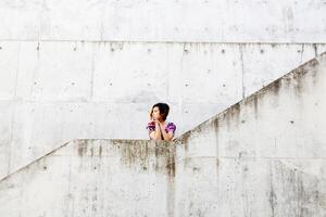 joven atractivo asiático americano mujer por cemento paredes foto