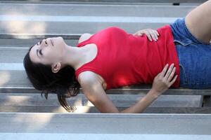 young latina teen girl reclining on bleachers photo