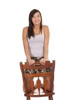joven asiático americano adolescente niña arrodillado en silla foto