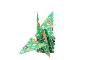 Folded origami paper crane green on white background photo