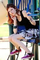 Young teen girl in skirt on playground equipment photo