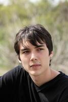 Young teen boy outdoor portrait black hair photo