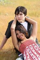 Young teen boy and girl outdoors reclining photo