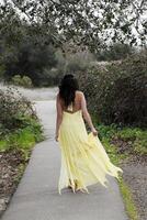 joven mujer caminando en amarillo vestir al aire libre foto