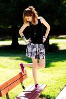 Young Caucasian Teen Girl Standing On Bench In Park photo