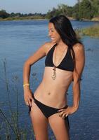 Slim Woman In Black Bikini Standing Next To River photo