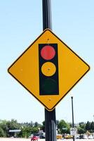 Traffic signal ahead sign against blue sky with autos photo