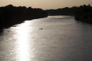 solitario kayac en río temprano Mañana silueta foto