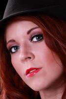 Attractive redhead young woman in black hat photo