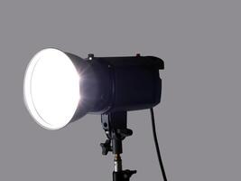 Studio monolight flash unit firing against gray background photo