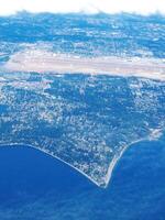 aéreo imagen de costa con Oceano edificios y nubes foto