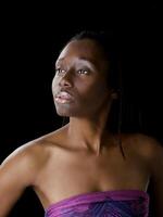 Portrait of young black woman against dark background photo