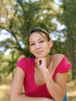 Young asian american woman portrait outdoors pink top photo