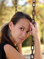 Young asian american woman on swing chains photo