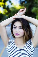 Asian American Woman Outdoor Portrait Arms On Head photo