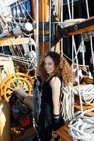 Attractive Mixed Race Young Woman Standing Next To Mast On Ship photo