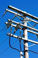 Tight Shot Of Wooden Power Pole Against Blue Sky photo