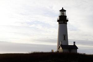 Lighthouse Standing On Hill With Cloudy Sky Newport Oregon photo