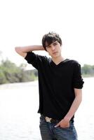 Young teen boy jeans and shirt outdoors photo