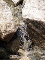 pequeño cascada en corriente entre granito rocas foto